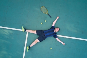 Tennisspieler völlig übermüdet am Boden