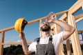 Bauarbeiter trinkt Wasser aus Wasserflasche bei Hitze auf der Baustelle