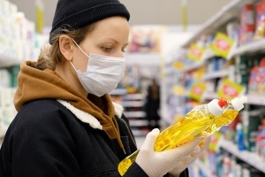 Frau mit Schutzmaske im Supermarkt