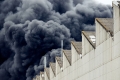 Schwarze Rauchwolken über Fabrikgebäude