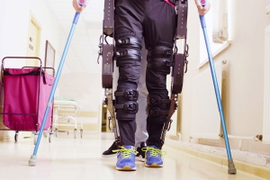 Mann in Krankenhaus mit Krücken und Exoskelett