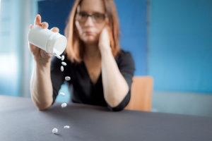 Frau leert Tabletten auf Tisch