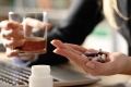 Frau mit Whiskeyglas und Hand voller Tabletten
