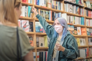 2 Frauen vor Bücherregal in Buchhandlung