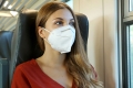 Frau mit FFP2-Maske in einem Zug