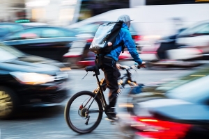 Fahrradbote unterwegs im Verkehr