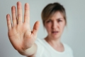 Frau hält Arm und Hand gestreckt vor den Körper - Signal: Stopp!