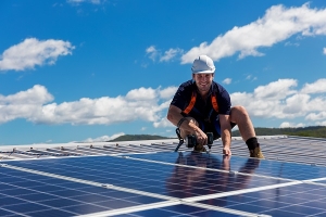 Techniker einer Solaranlage am Dach bei Sonne