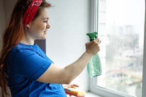 Schwangere Frau reinigt ein Fenster