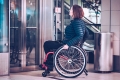 Frau im Rollstuhl wartet auf Lift