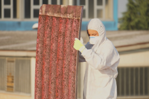 Arbeiter entsorgt eine Asbestplatte